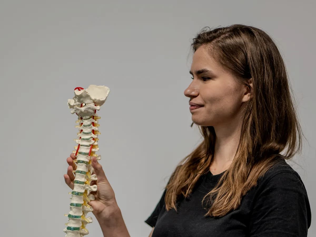 Edukacja pacjenta — fizjoterapeutka M&M prezentuje anatomiczny model kręgosłupa lędźwiowego